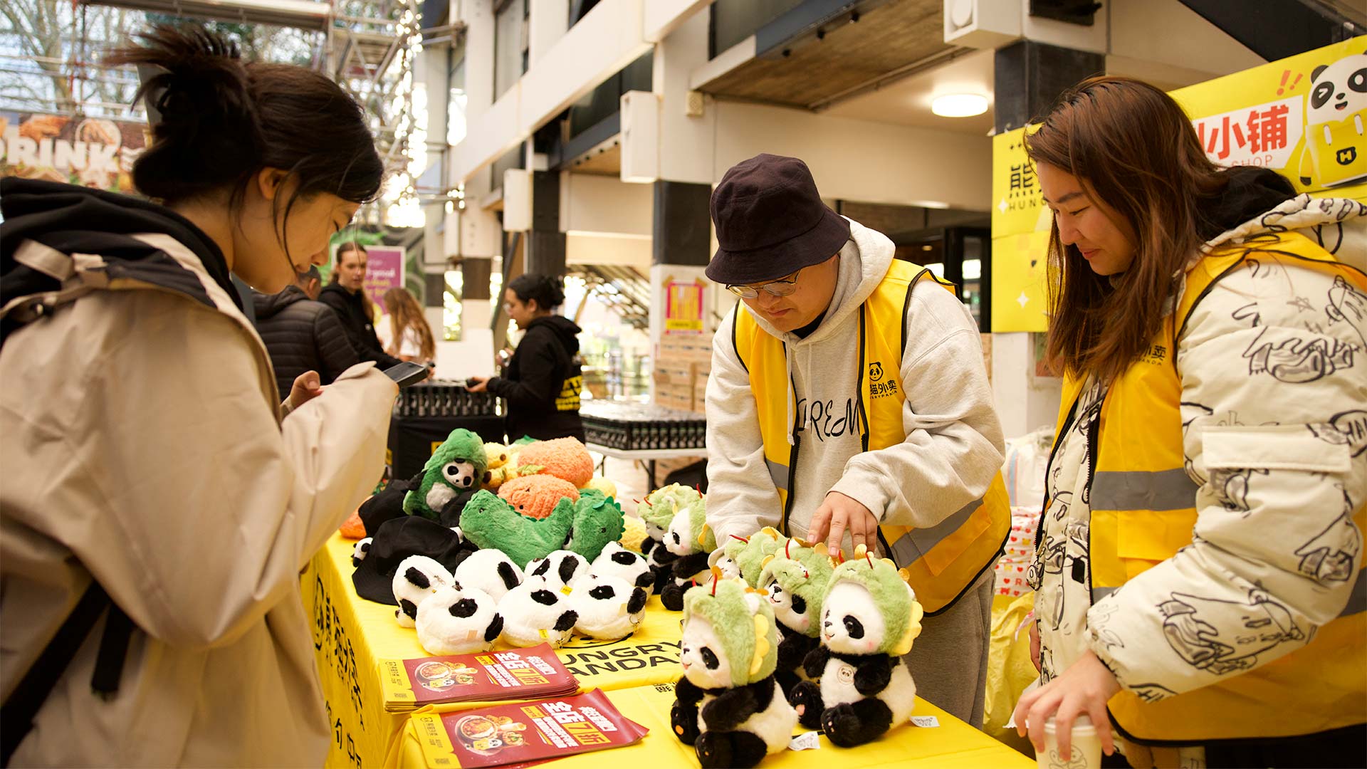 Hungry Panda brand giving out little plushie pandas and leaflets at a yellow stall on campus